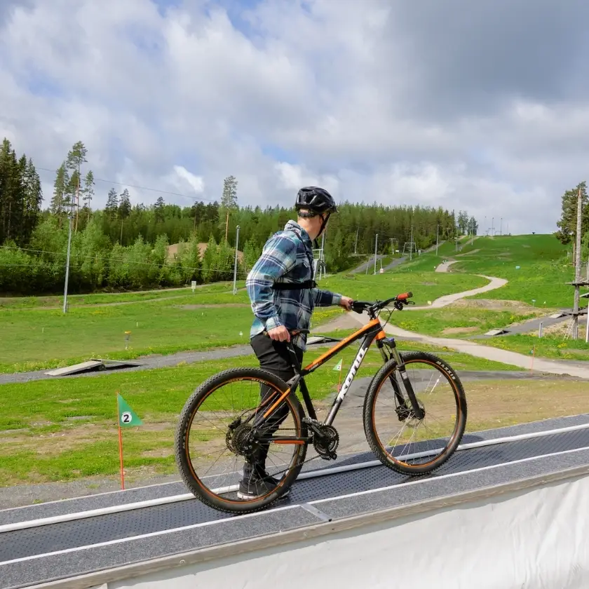 Aloittelija harjoittelee alamäkipyöräilyä ensimmäistä kertaa Laajis treeniparkin turvallisessa ympäristössä