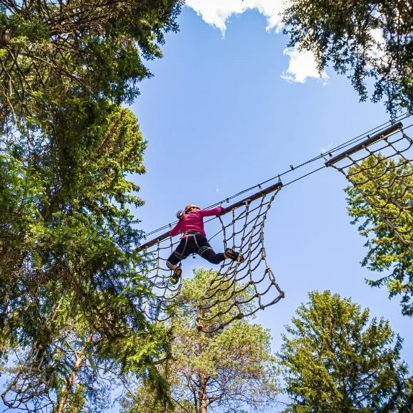 Nainen kiipeilee köysiradalla Laajis seikkailupuistossa Laajavuoressa