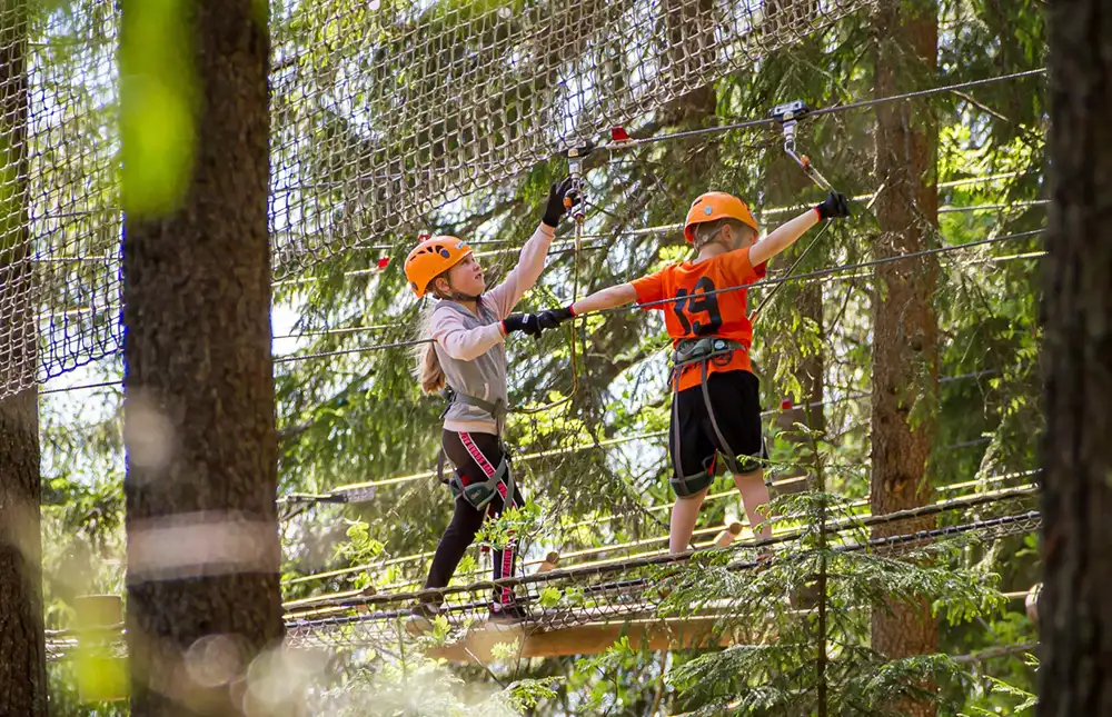 Koululaisryhmä valmistautuu seikkailuun Laajavuoren seikkailupuistossa.